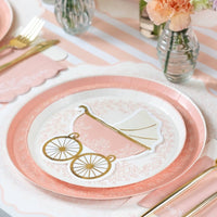 Pink striped table runner with carriage plate, flowers, and gold utensils