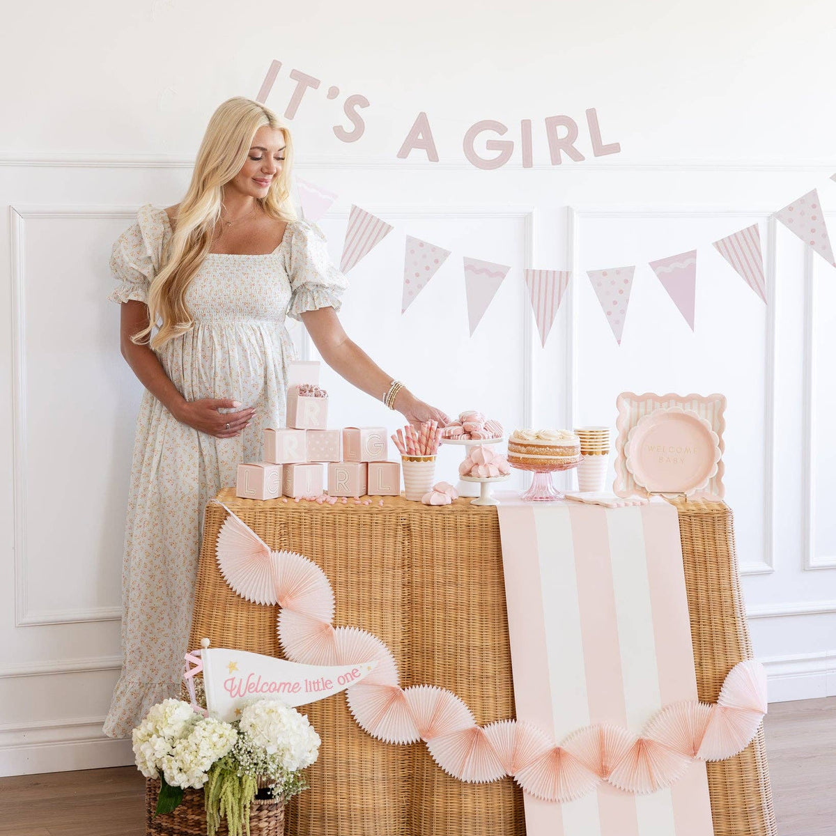 Baby shower table setup with pink Welcome Baby plates
