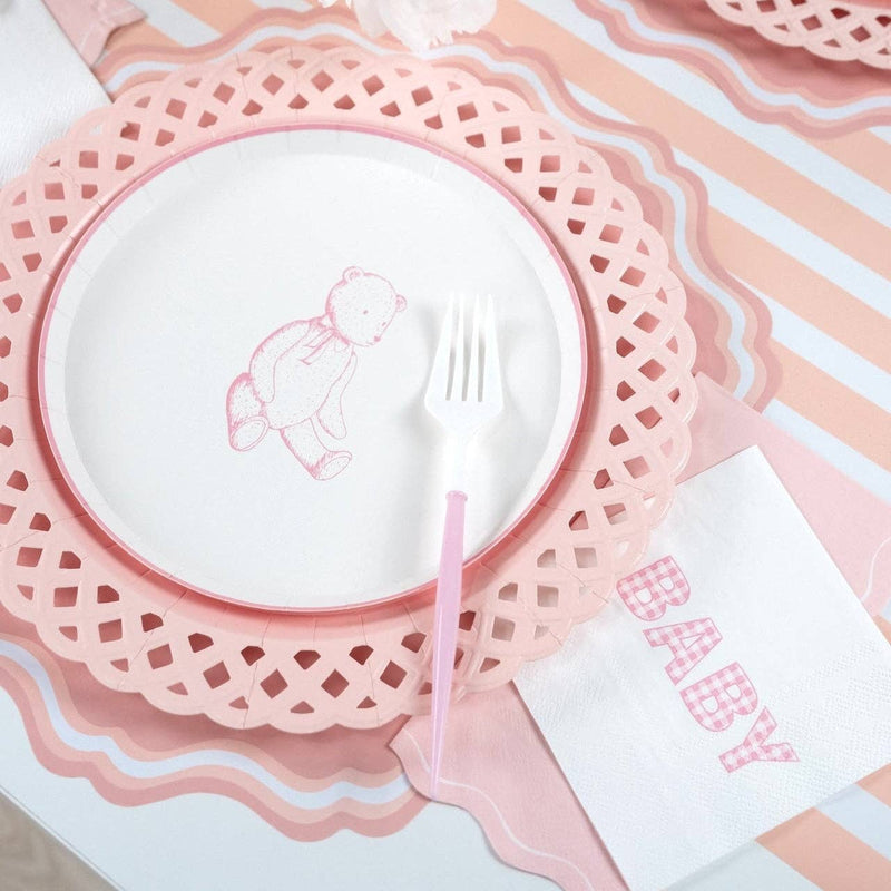 Styled baby shower place setting showing the pink napkin with a bunny plate on a pink scalloped charger and pink-striped runner.