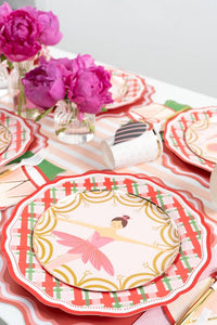 Overhead of ballerina and drum plates on plaid plates with pink peonies and a striped runner.