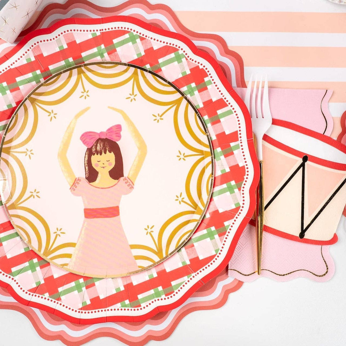 Place setting with a pink ballerina salad plate on the plaid dinner plate and a drum-print napkin.