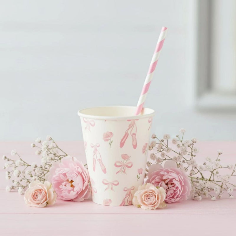 Ballerina cup on a pink table with a striped straw and fresh roses