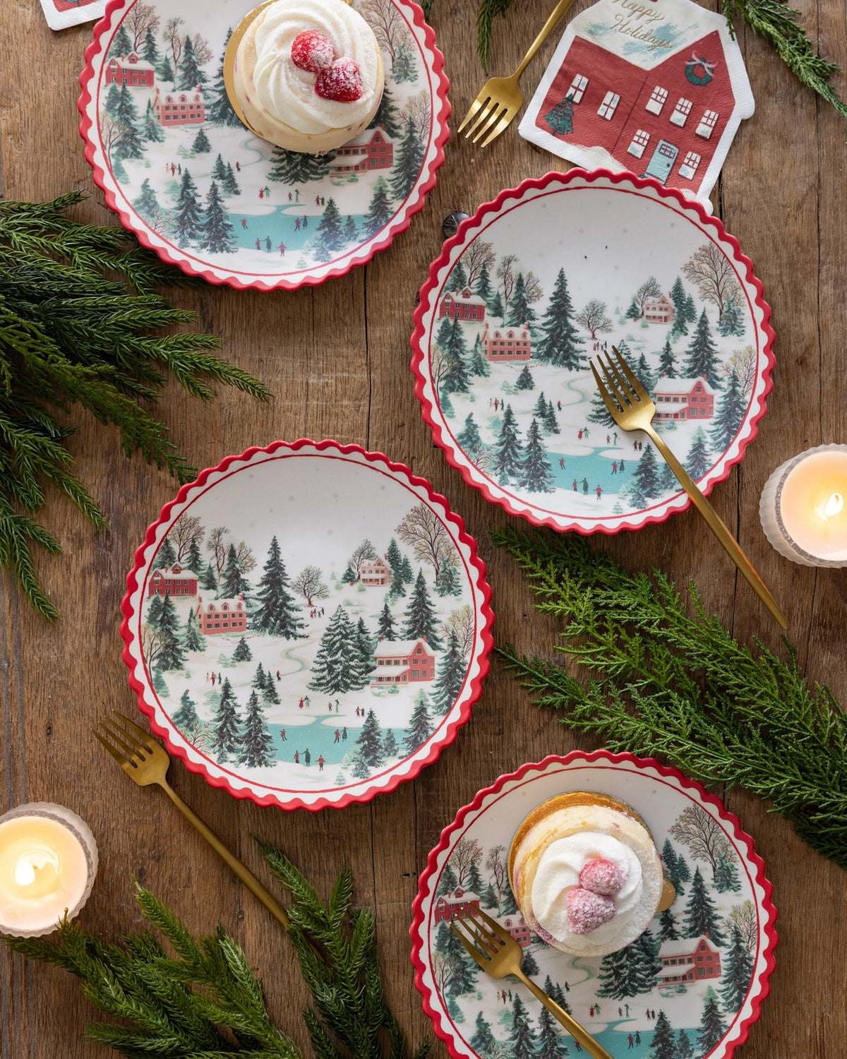 The bamboo plates with greenery and candles on a wood surface.