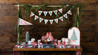 Rustic table with the bamboo tray, a Merry Christmas pennant banner, and a dessert spread.