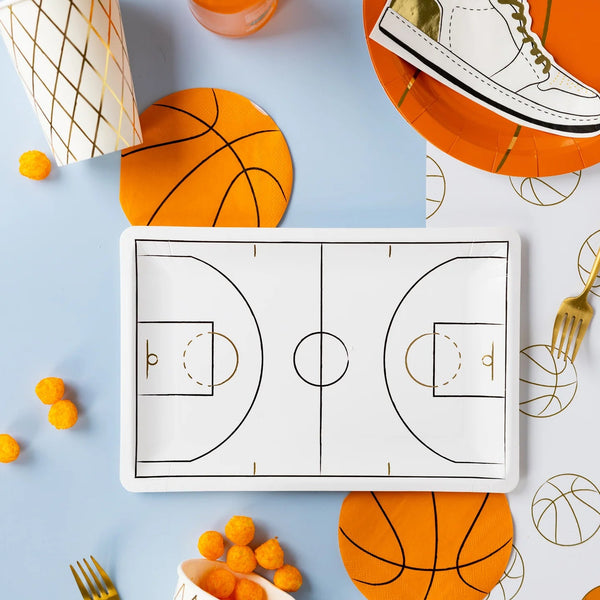 Game-day tablescape with court plate, orange basketball napkins, and cups.