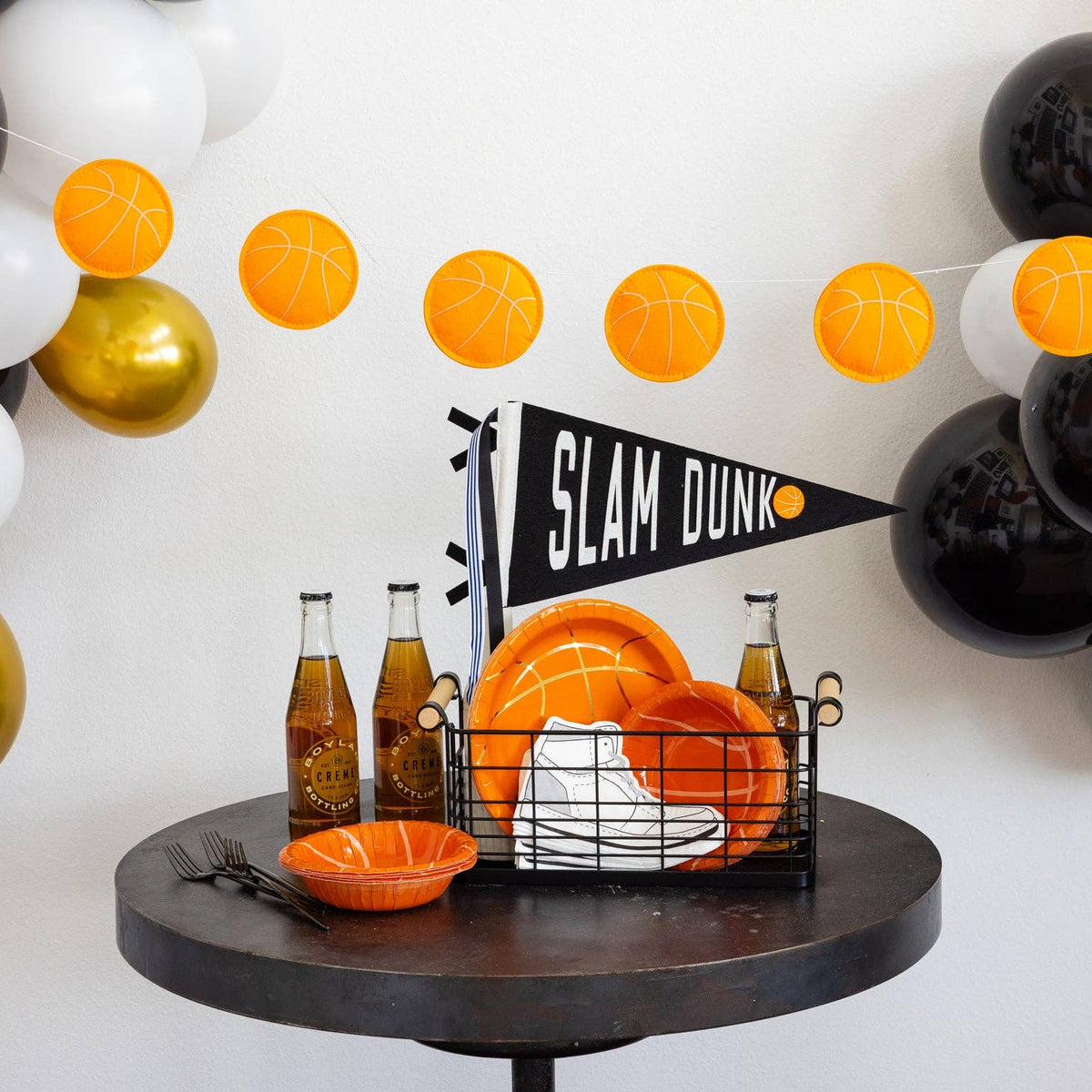 Basketball puffy felt banner displayed above a sports party table with basketball plates and decorations