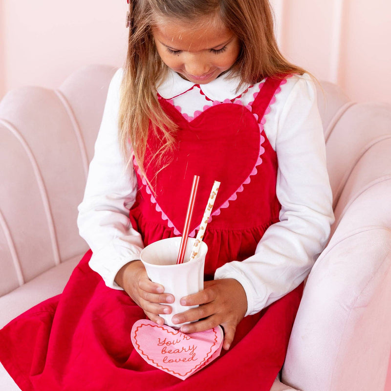 Child holding a drink with Beary Loved heart napkin underneath
