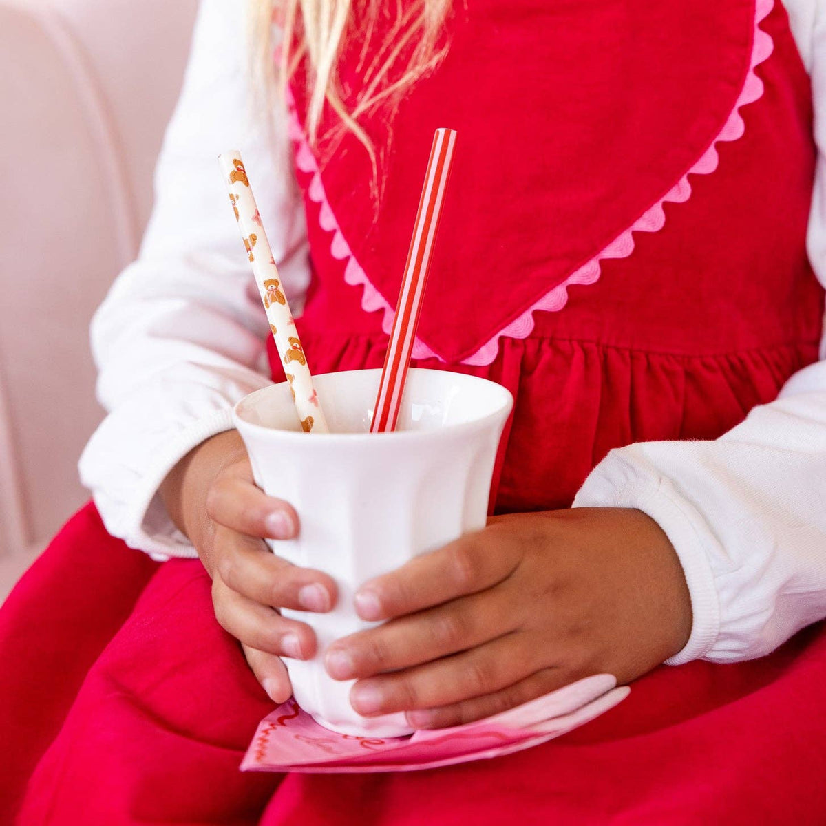 Child holding a drink with Beary Loved reusable straws