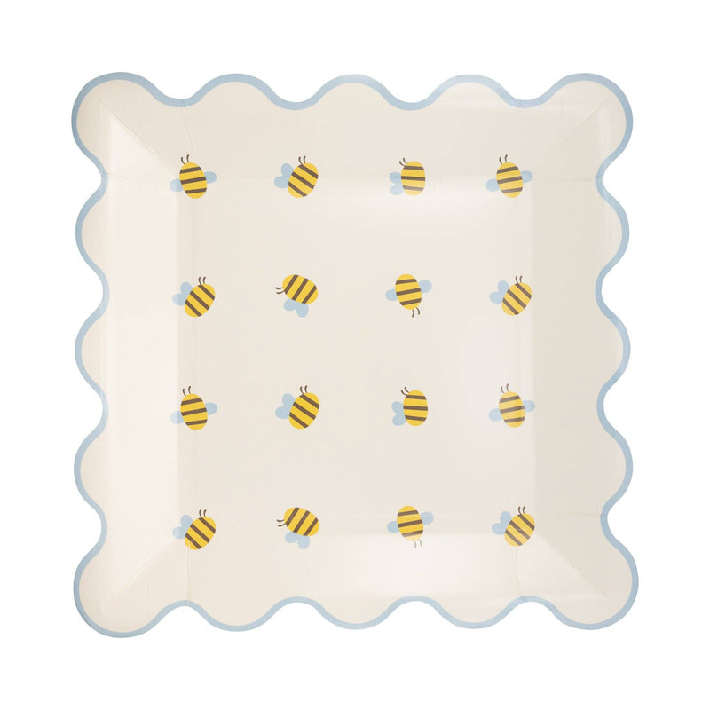 A square paper plate with a blue scalloped rim and a Honey hued palette bee pattern.