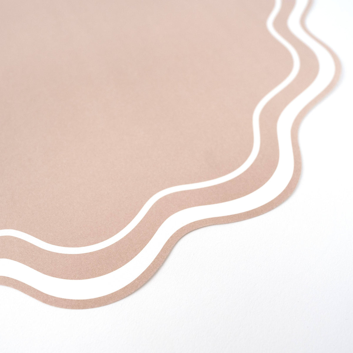 close up of beige wavy scalloped paper placemat edge detail
