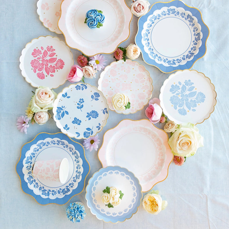 Full tablescape of Belle Blue dessert plates, cups, and florals arranged on linen.