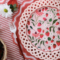 Close-up of a Strawberry Paper Plate layered on a pink lattice charger for a Berry Sweet 1st Birthday Aesthetic.