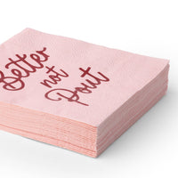 Stack of folded pink "Better Not Pout" cocktail napkins showing the red script and pink color from an angle.
