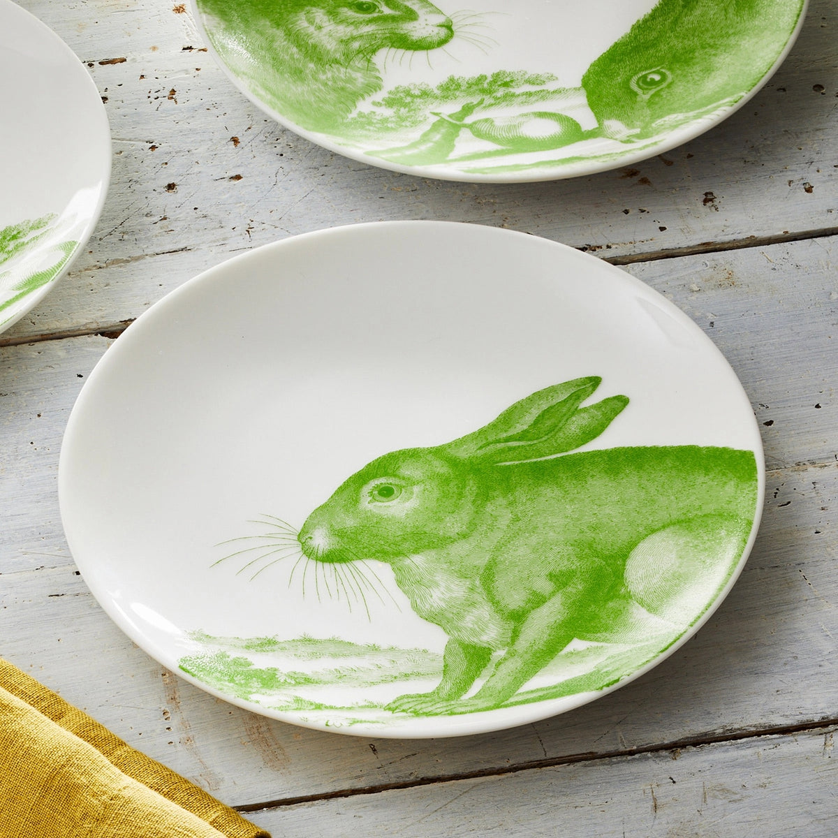 White ceramic appetizer plates with green bunny designs.