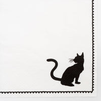 Extreme close up macro detail of the black cat silhouette and the delicate printed picot-stitch edge on the white 3-ply paper napkin.