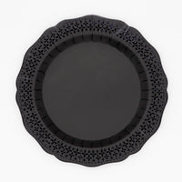 Top-down studio shot of a solid black paper dinner plate with an intricate die-cut lace scalloped border on a white background.