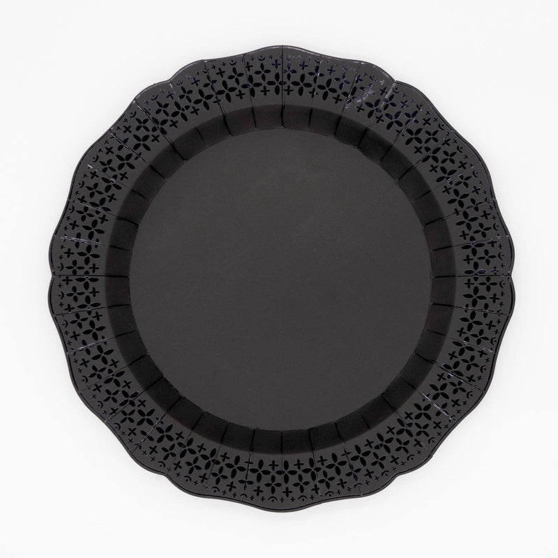 Top-down studio shot of a solid black paper dinner plate with an intricate die-cut lace scalloped border on a white background.