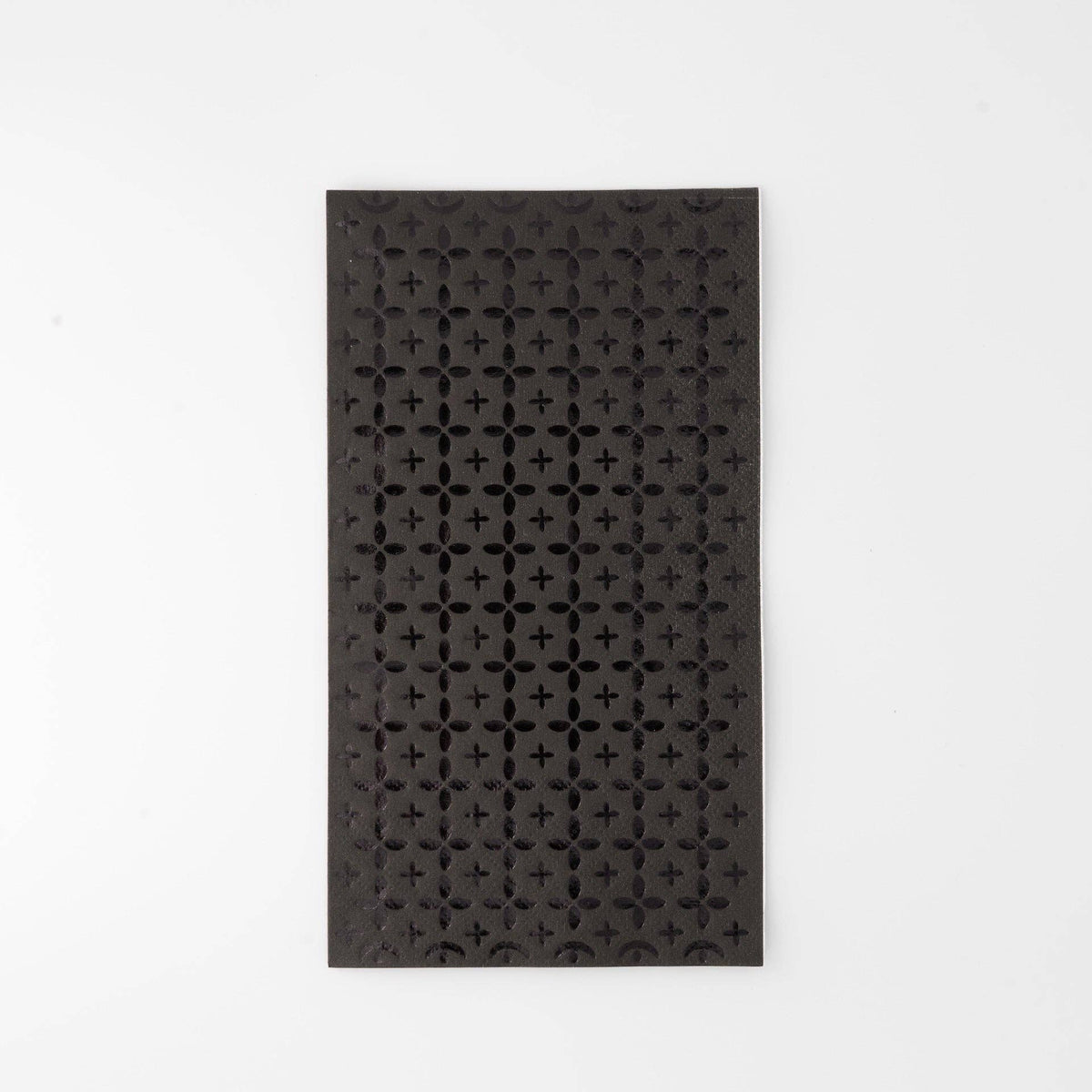 Black paper guest towel with a tone-on-tone black foil cross/plus geometric pattern, flat view on white background.