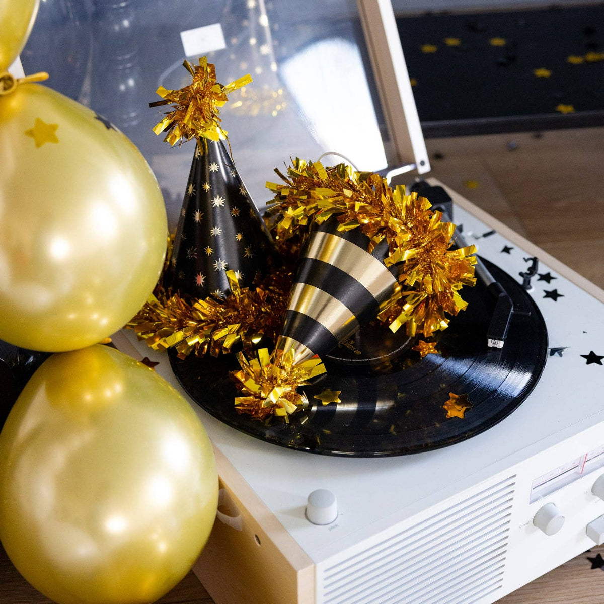 Close-up of black and gold party hats on record player