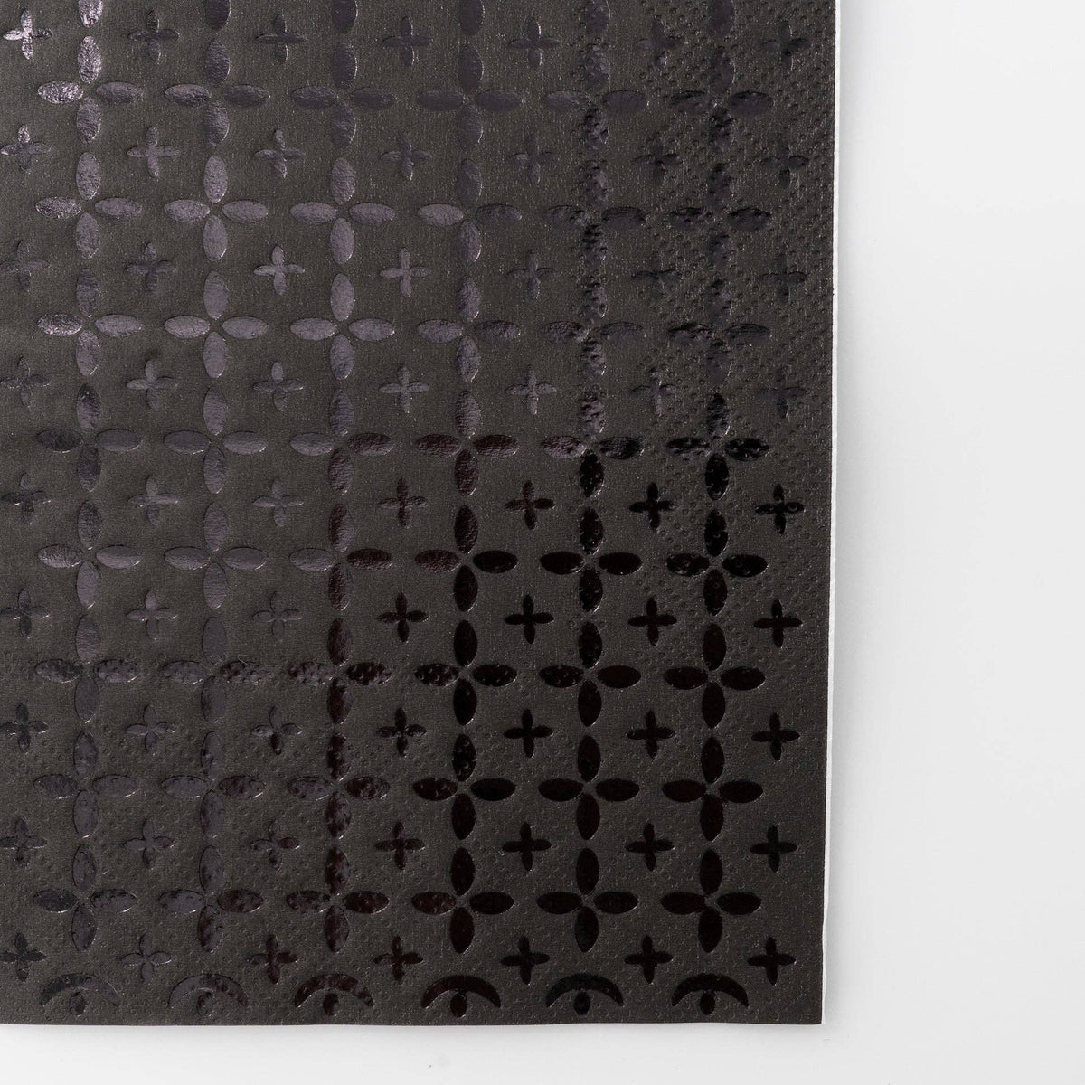 Extreme close-up of the black-on-black foil cross pattern texture showing the geometric detail.