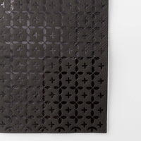 Extreme close-up of the black-on-black foil cross pattern texture showing the geometric detail.