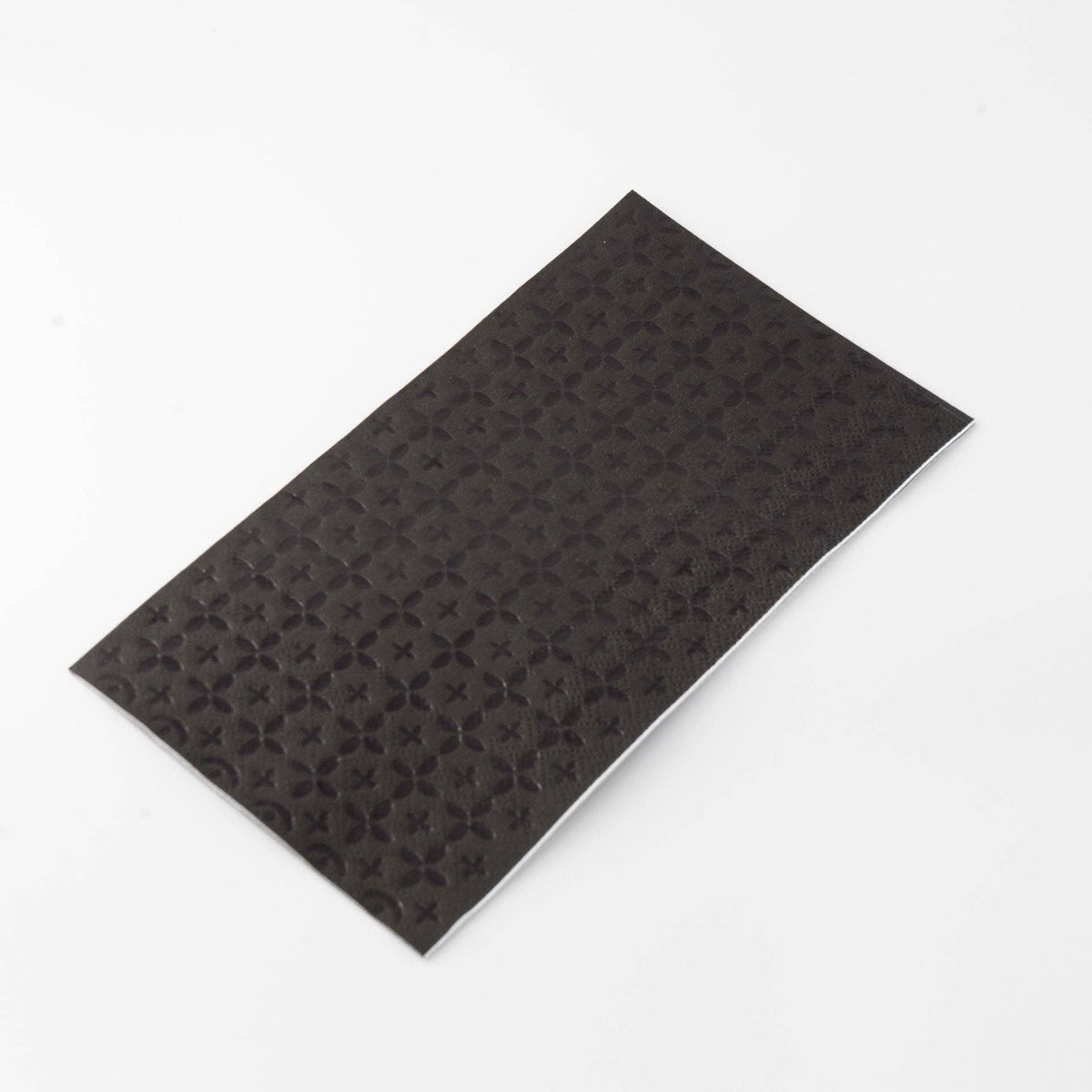 Another angle of the black foil guest towel folded, showing the premium paper weight.