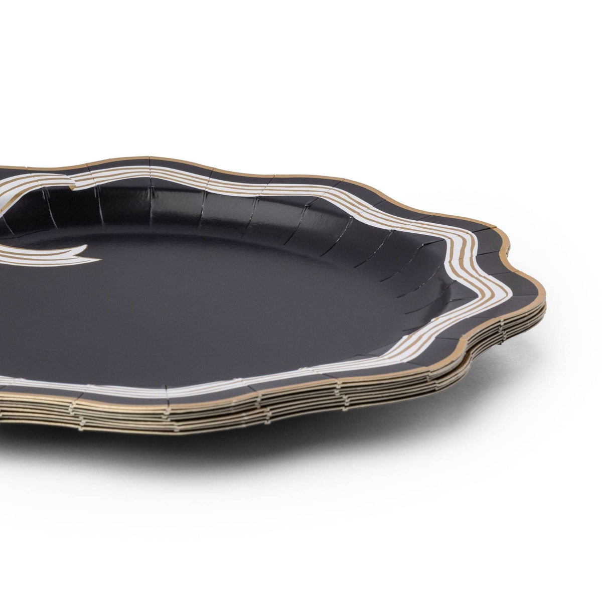 Angled view of the black and white bow plate showing the scalloped gold-trimmed edge and striped rim depth.