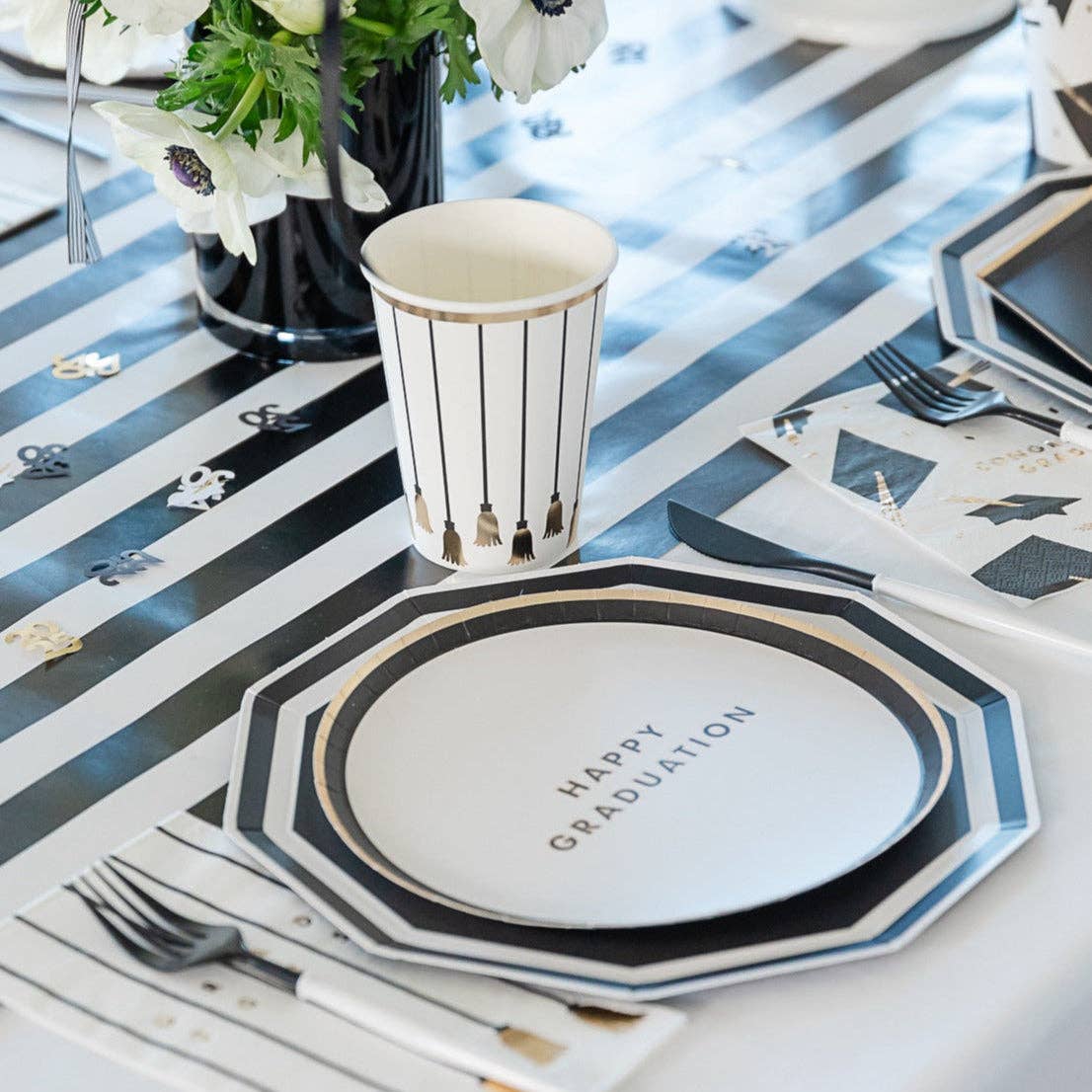 Graduation table setting with black and white decagon plate and party decorations