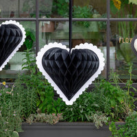 Black and white honeycomb heart hanging in a storefront window for Valentine’s Day