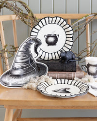 Style Halloween-themed table setting with the black witch hat paper plates layered on a wooden surface.
