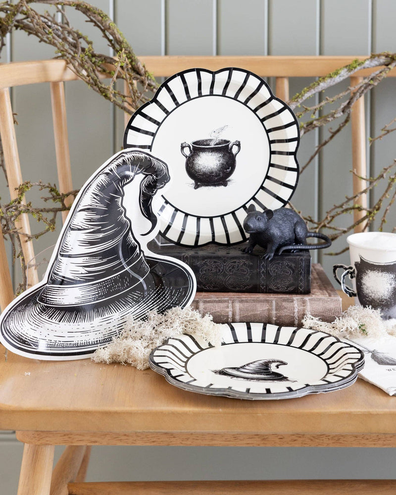 Style Halloween-themed table setting with the black witch hat paper plates layered on a wooden surface.