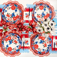 Full table setting showing the 10.5 inch Scalloped Paper Plates mixed with floral and striped motifs.