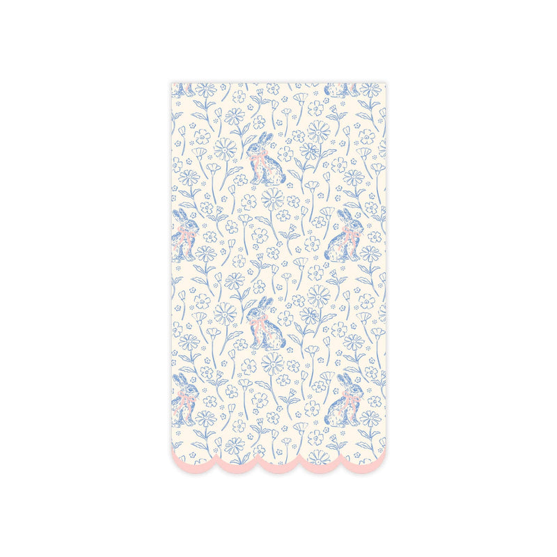 A single paper guest napkin featuring a blue and white floral bunny pattern with a pink scalloped edge.