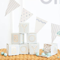 Blue baby block treat boxes stacked spelling BOY on wicker table