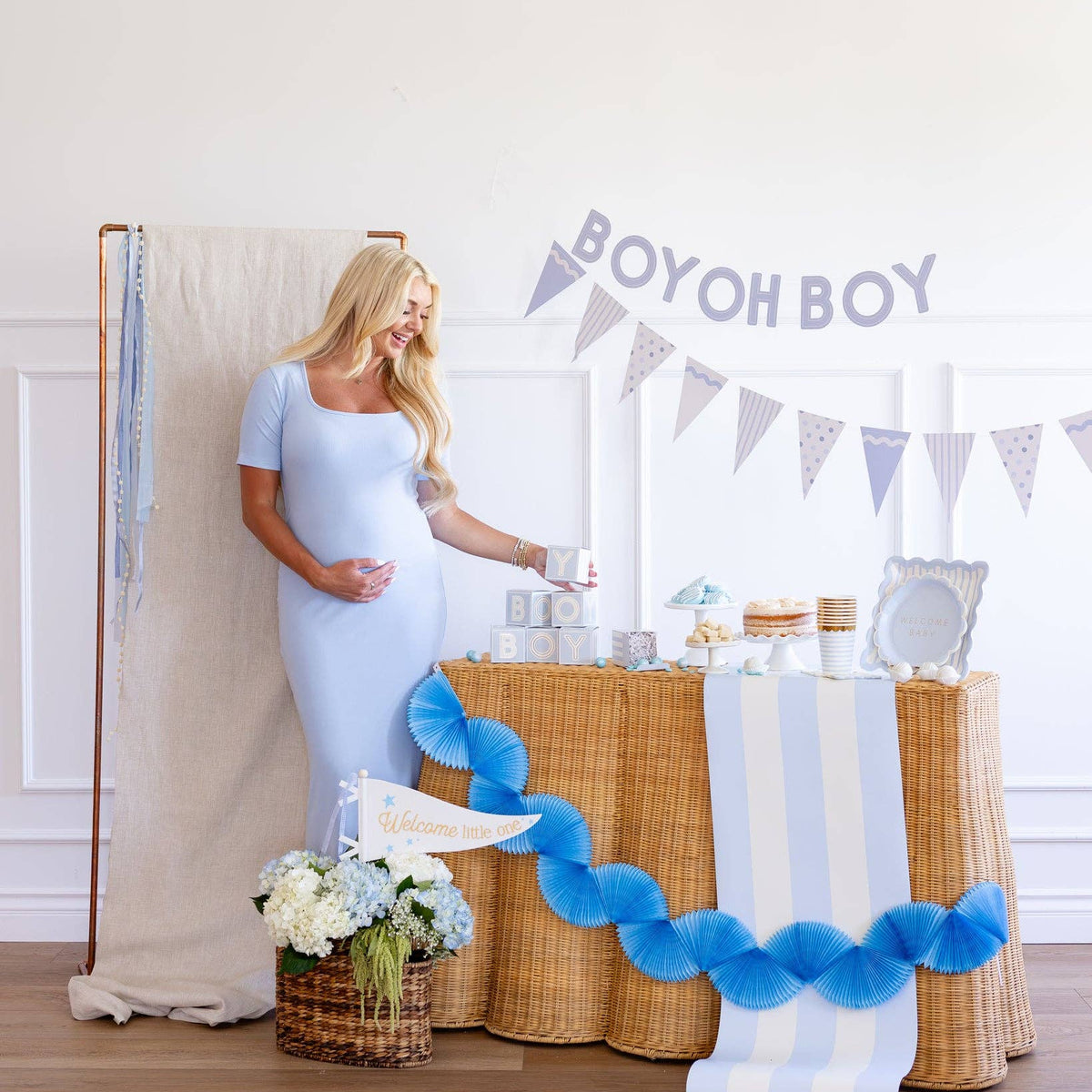 Baby shower table styled with blue block treat boxes and decorations