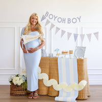 Blue baby shower setup with Welcome Little One pennant and dessert table