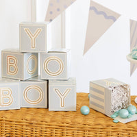 Close-up of stacked blue baby block boxes spelling BOY