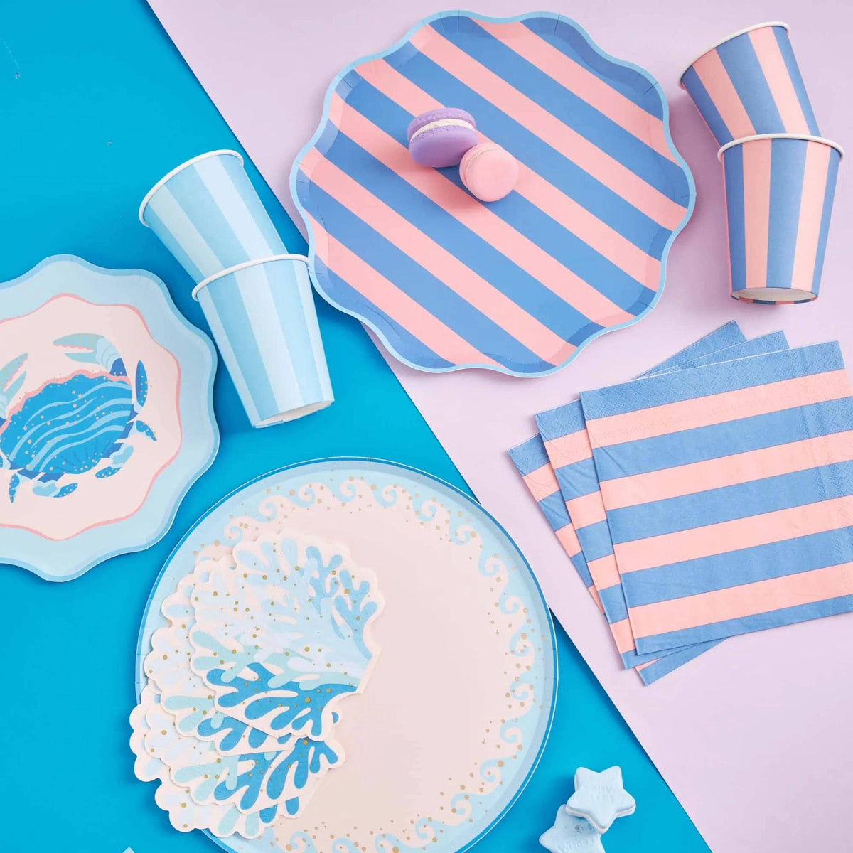 Blue cabana stripe cups in a Coastal Catch party display with crab plates, wave plates, striped plates, and coral napkins.