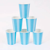 Six blue cabana stripe paper party cups stacked in a pyramid on a white background.