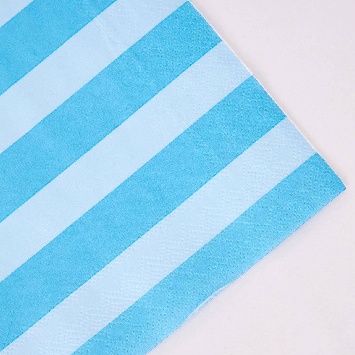 Angled corner detail of blue and white striped paper napkin