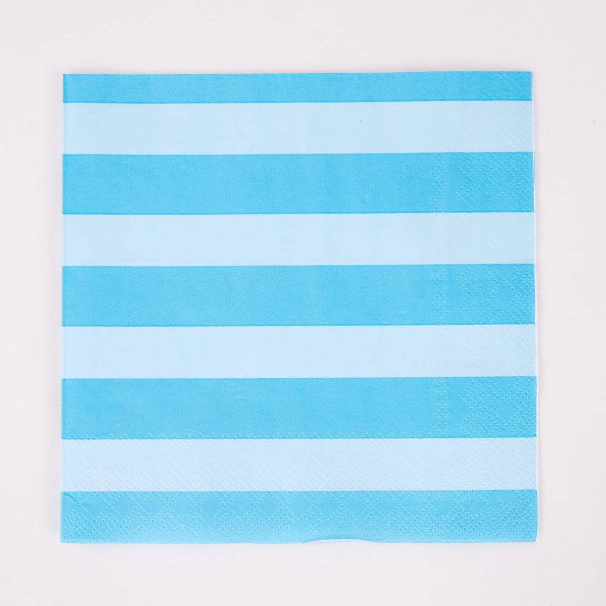 Single blue and white cabana stripe paper lunch napkin flat on white
