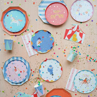 Blue cabana stripe paper plates in a circus party assortment with colorful round plates featuring unicorns, leopards, and acrobats