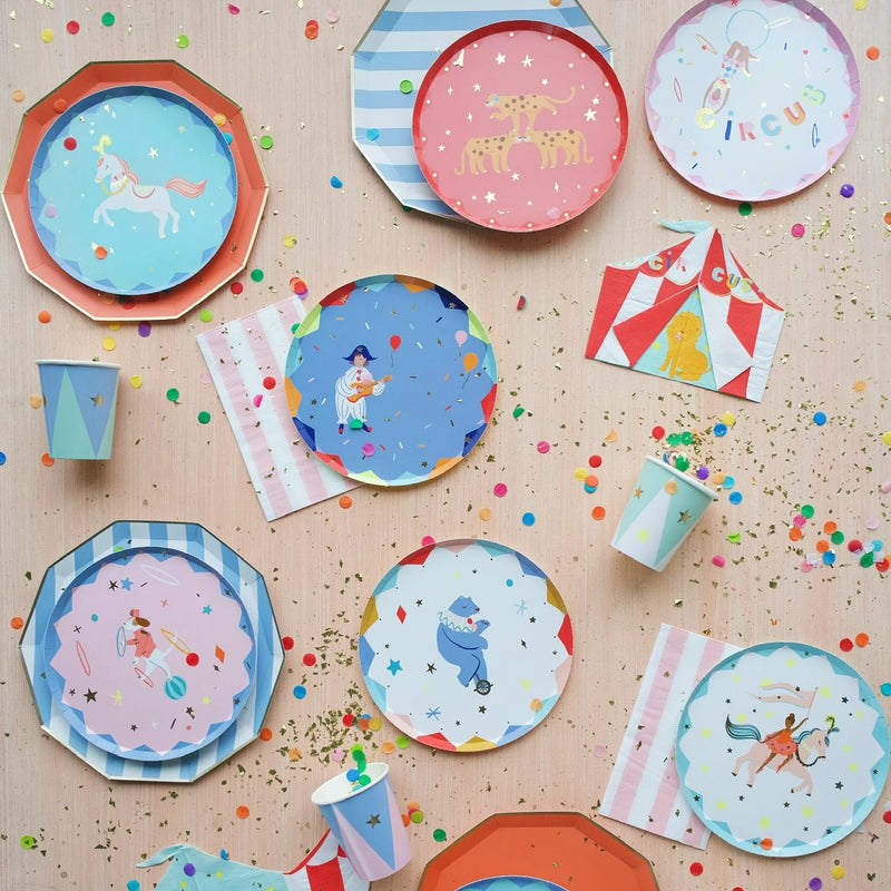 Blue cabana stripe paper plates in a circus party assortment with colorful round plates featuring unicorns, leopards, and acrobats