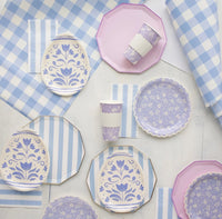 Blue cabana stripe paper plates layered with lavender folk-floral plates on a blue gingham Easter tablescape