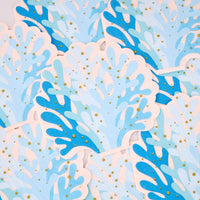 Overlapping blue coral shaped napkins with layered blue tones, blush edges, and gold foil dots.
