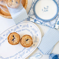 Blue floral Easter paper plates styled with matching blue spring tableware and baked goods.