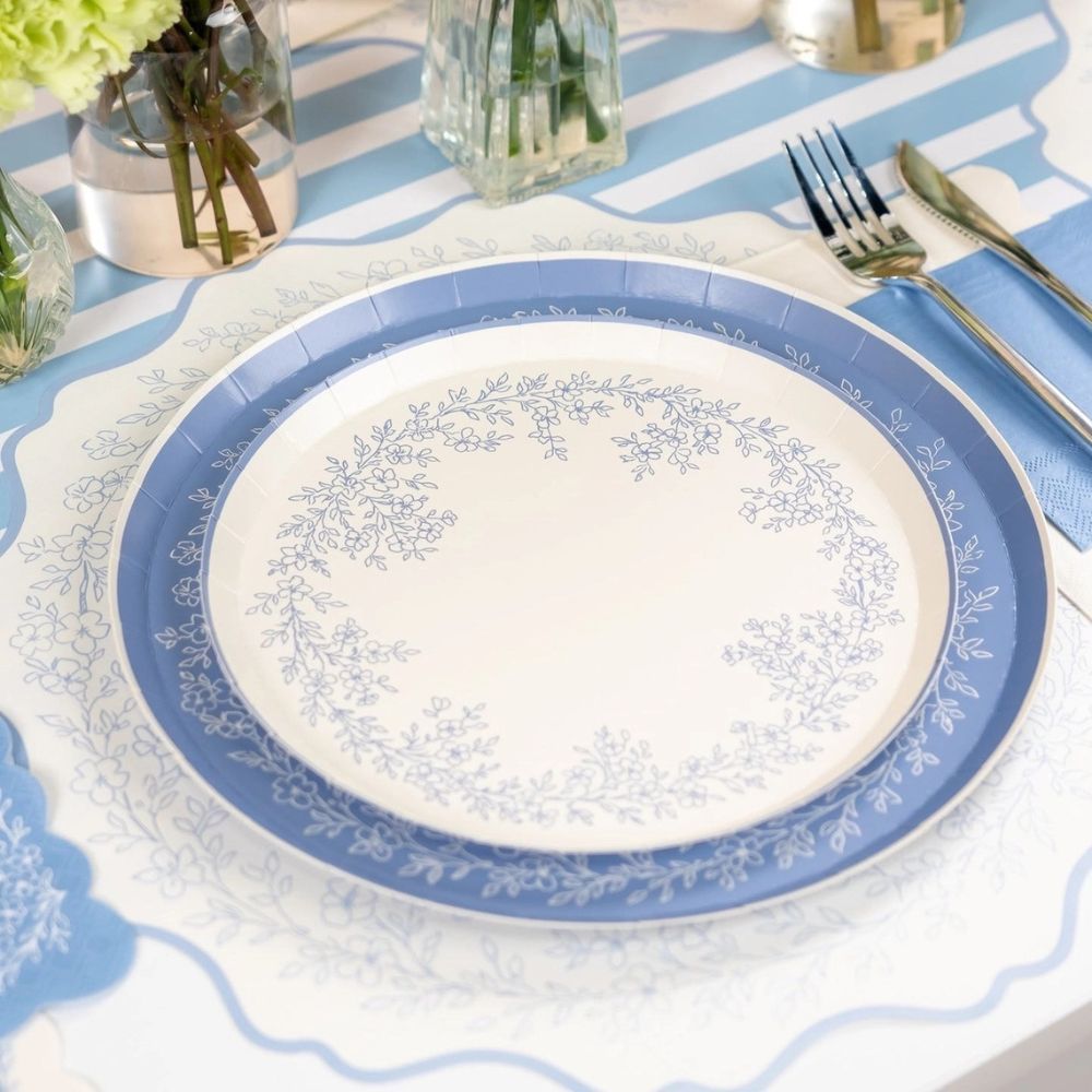 blue floral placemats styled with tableware and floral centerpieces.