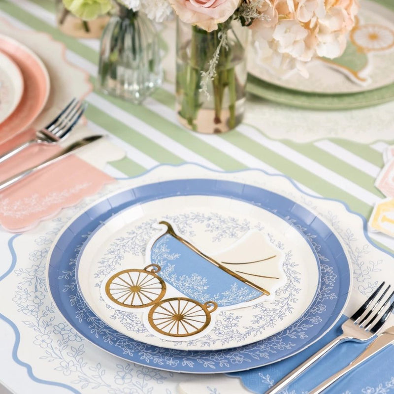blue floral placemat layered under matching table setting with plates and napkins.
