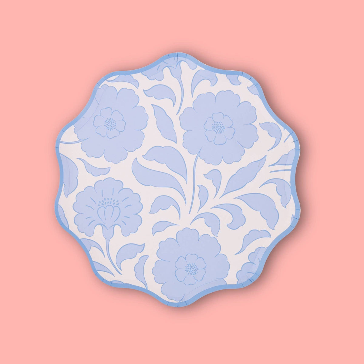 Single periwinkle-blue block-print floral scalloped paper plate on a pink background.