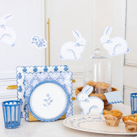 Blue floral Easter table setting with coordinating plates, bunny decor, and spring party supplies.